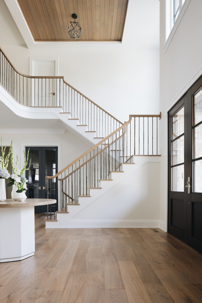 Свежая идея для дизайна: большая п-образная лестница в стиле неоклассика (современная классика) с деревянными ступенями, крашенными деревянными подступенками и перилами из смешанных материалов - отличное фото интерьера