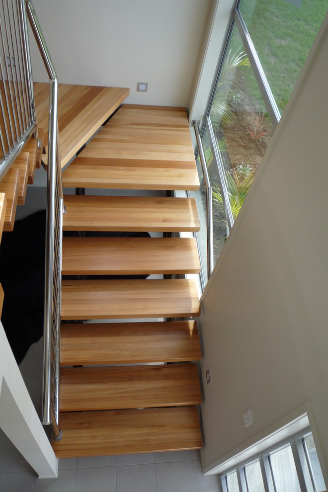 This is an example of a medium sized industrial wood floating staircase in Auckland with open risers.