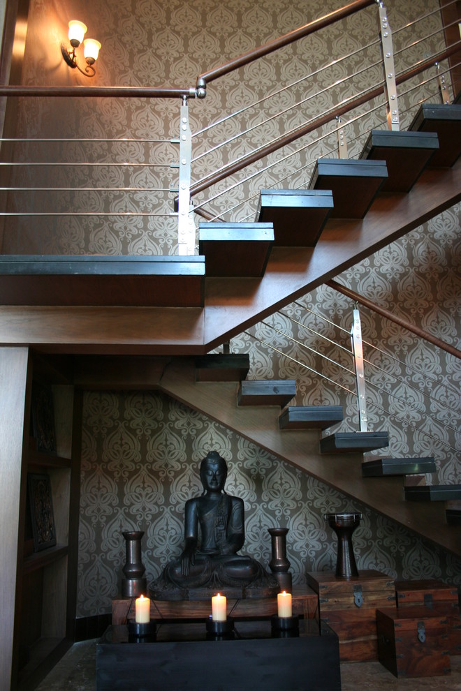 На фото: большая п-образная лестница в средиземноморском стиле с деревянными ступенями и перилами из тросов без подступенок