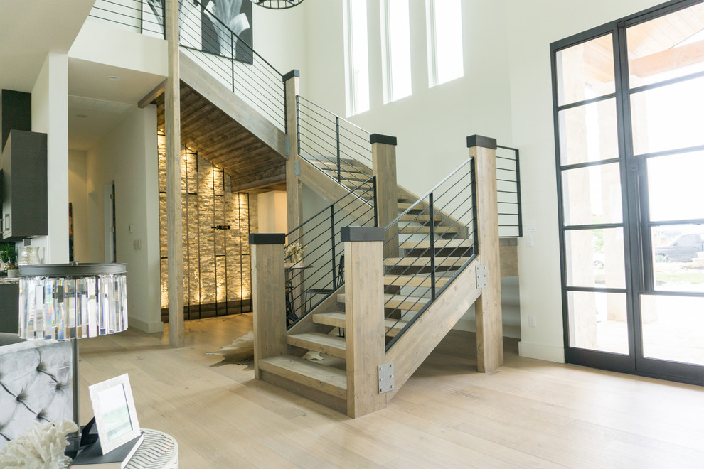 Große Moderne Holztreppe in U-Form mit offenen Setzstufen und Stahlgeländer in Austin