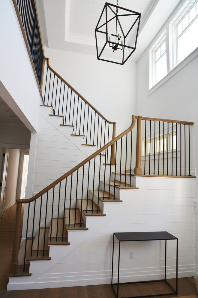 Идея дизайна: большая п-образная лестница в стиле неоклассика (современная классика) с деревянными ступенями, крашенными деревянными подступенками и перилами из смешанных материалов