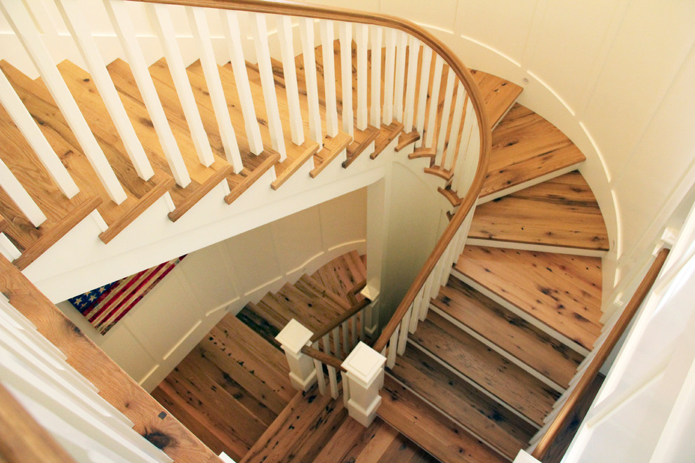This is an example of a large nautical wood u-shaped staircase in Orange County with painted wood risers.