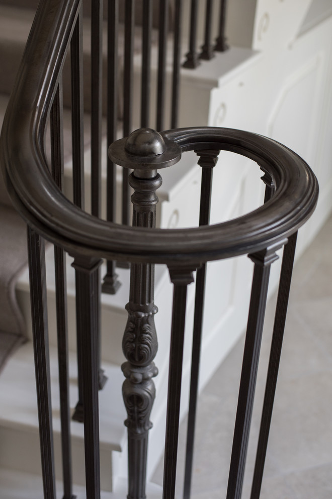 Foto de escalera en L clásica grande con escalones de madera pintada, contrahuellas enmoquetadas y barandilla de metal