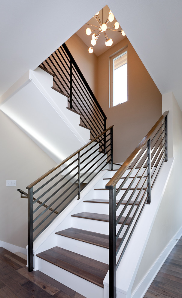 Aménagement d'un escalier contemporain avec des marches en bois, un garde-corps en matériaux mixtes et palier.