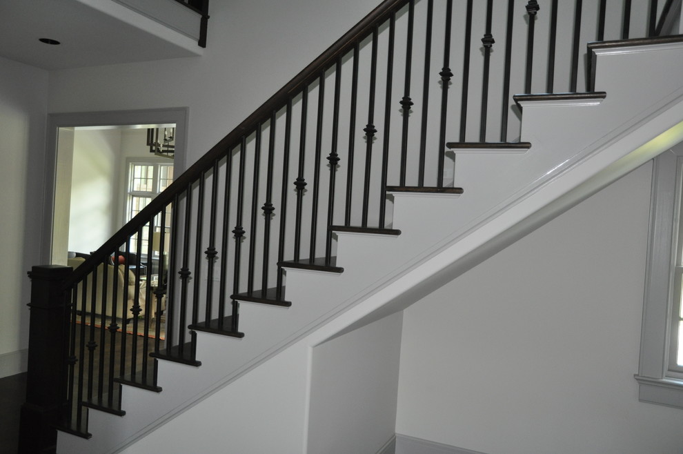 Ejemplo de escalera recta clásica renovada grande con escalones de madera, contrahuellas de madera pintada y barandilla de metal