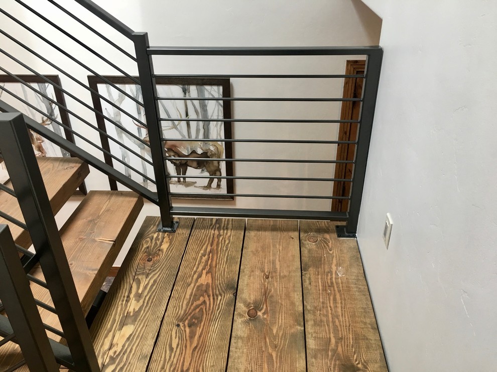 Diseño de escalera suspendida contemporánea grande con escalones de madera, contrahuellas de madera y barandilla de metal