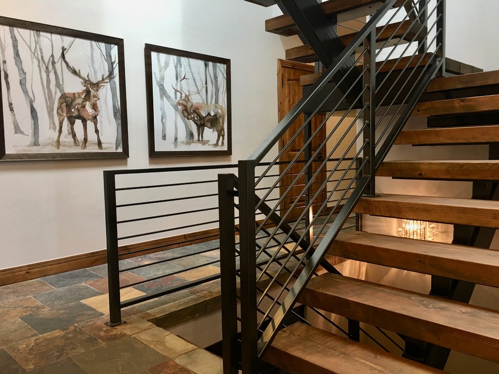 Foto de escalera suspendida actual grande con escalones de madera, contrahuellas de madera y barandilla de metal