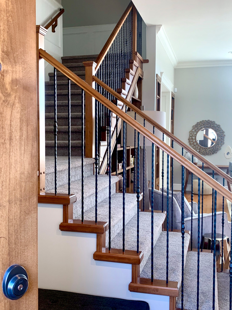 Пример оригинального дизайна: большая угловая лестница в стиле ретро с ступенями с ковровым покрытием, ковровыми подступенками и деревянными перилами