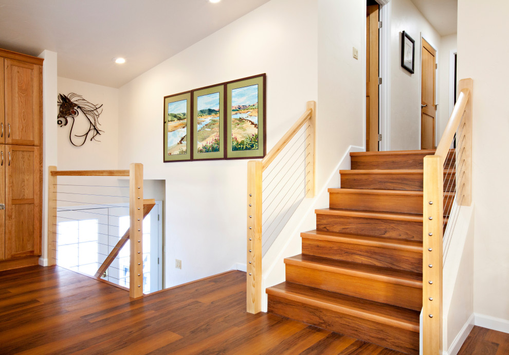 他の地域にある広いトランジショナルスタイルのおしゃれな直階段 (木材の手すり) の写真