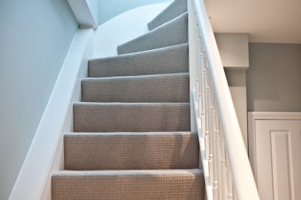 Inspiration for a mid-sized carpeted curved staircase remodel in London with carpeted risers