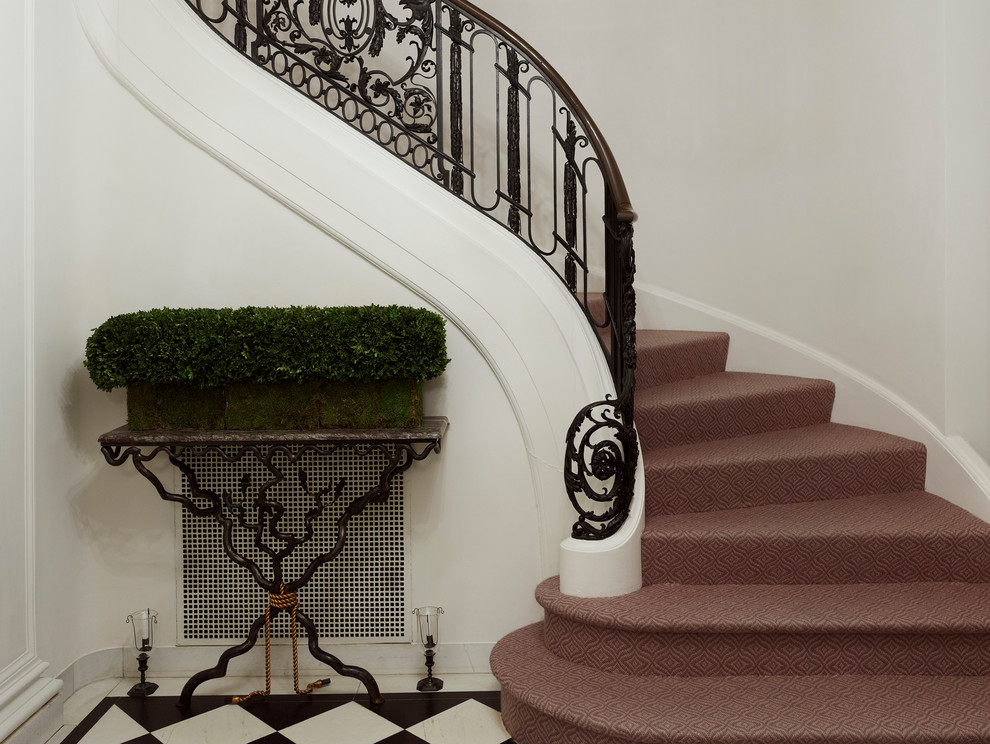 Inspiration för en mellanstor vintage svängd trappa, med heltäckningsmatta, sättsteg med heltäckningsmatta och räcke i metall