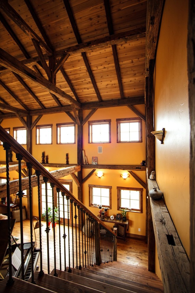 Photo of a large rustic wood straight mixed railing staircase in Denver with open risers.