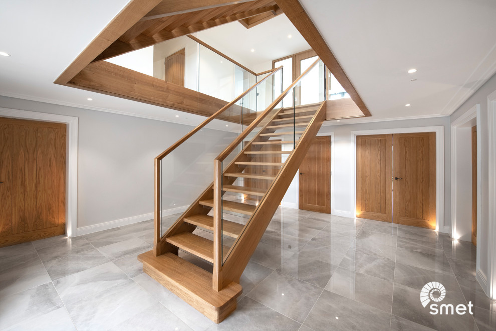 Стильный дизайн: прямая лестница в современном стиле с деревянными ступенями и стеклянными перилами без подступенок - последний тренд