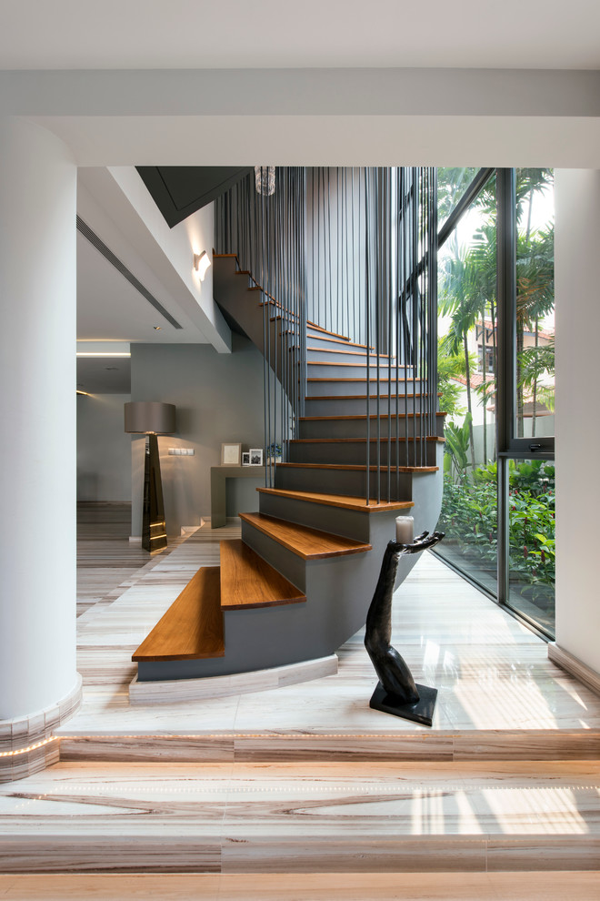 На фото: изогнутая лестница в современном стиле с деревянными ступенями с