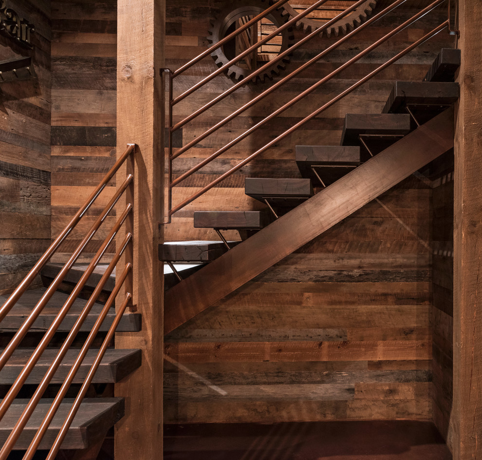 На фото: большая п-образная лестница в стиле рустика с деревянными ступенями и металлическими перилами без подступенок с