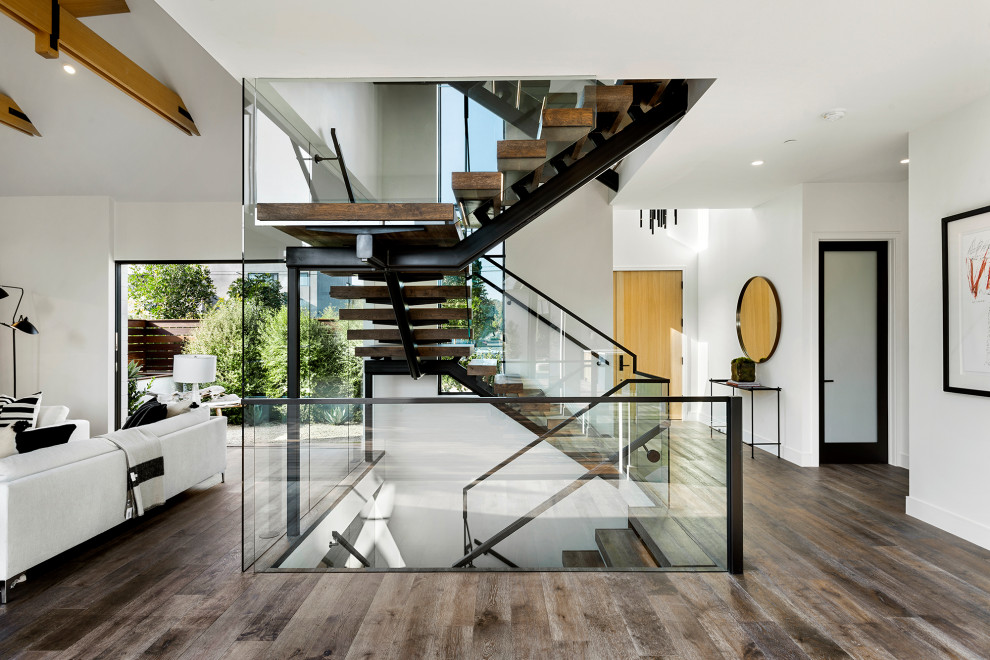 Ejemplo de escalera suspendida marinera grande con escalones de madera y barandilla de vidrio