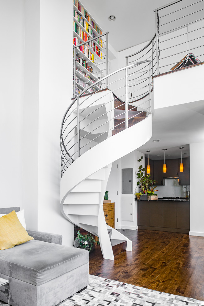 На фото: винтовая металлическая лестница среднего размера в современном стиле с деревянными ступенями с