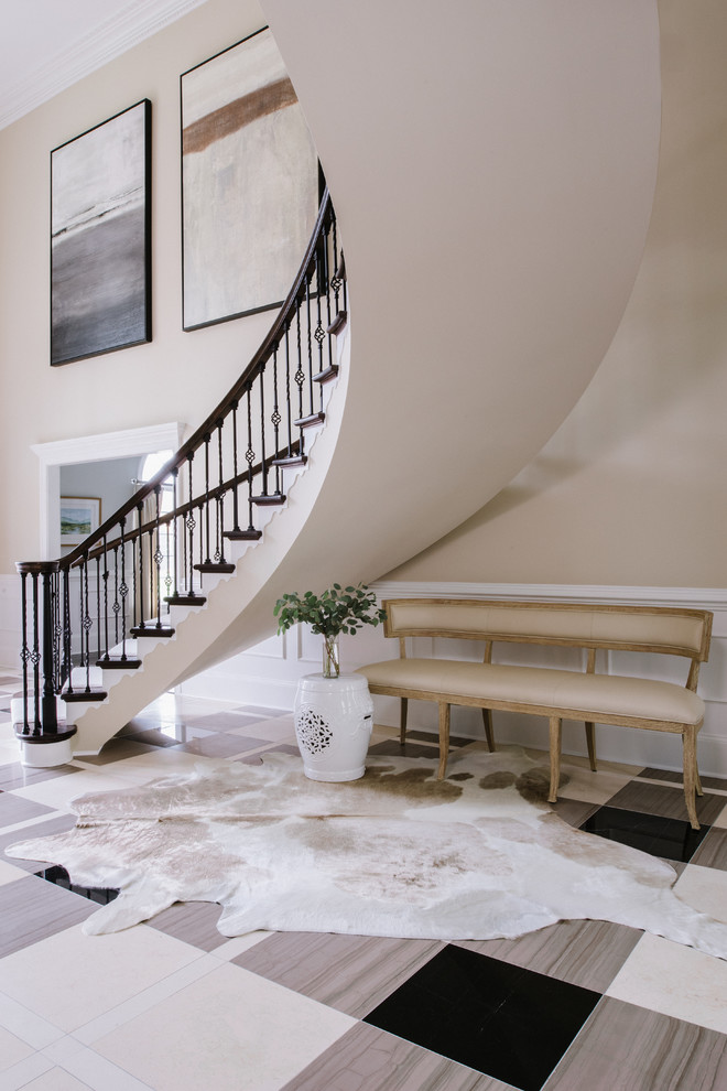 Стильный дизайн: изогнутая лестница в классическом стиле с деревянными ступенями, крашенными деревянными подступенками и металлическими перилами - последний тренд
