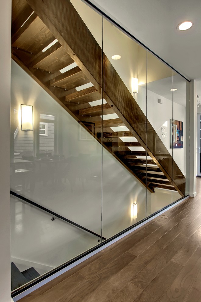 Photo of a contemporary wood staircase in Seattle with open risers and feature lighting.
