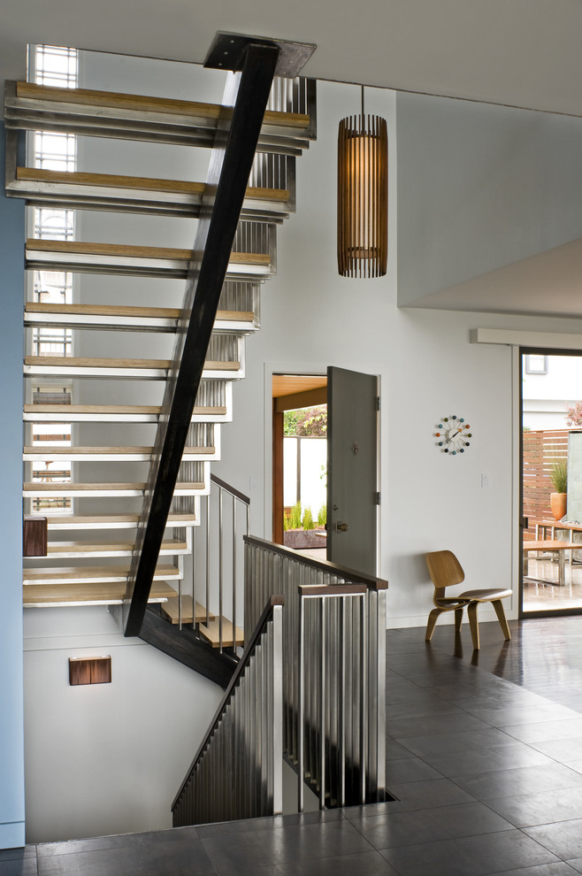 На фото: лестница в стиле модернизм с металлическими перилами без подступенок с