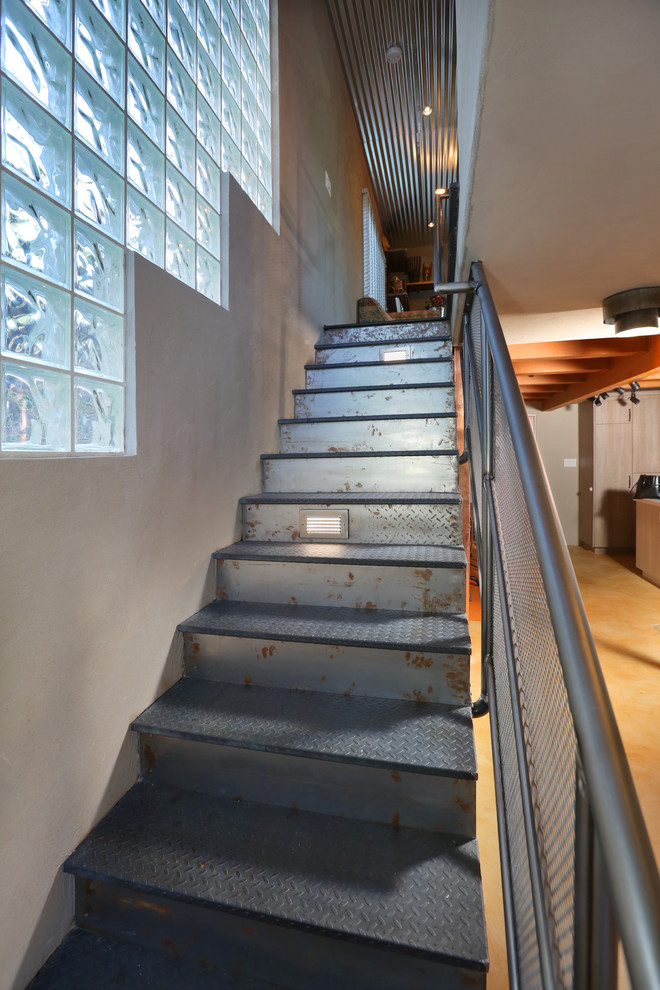 Imagen de escalera recta urbana grande con escalones de metal y contrahuellas de metal
