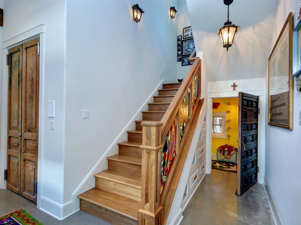 オースティンにあるラグジュアリーな広いエクレクティックスタイルのおしゃれな階段 (木の蹴込み板、混合材の手すり) の写真