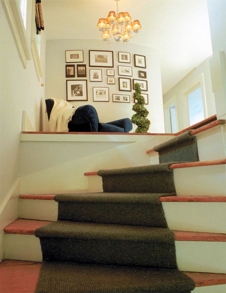 Foto de escalera curva clásica pequeña con escalones de madera y contrahuellas de madera pintada