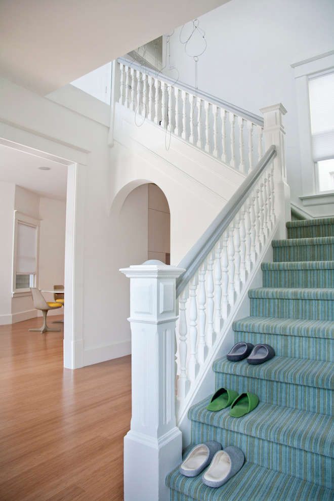 На фото: лестница в стиле неоклассика (современная классика) с ступенями с ковровым покрытием и ковровыми подступенками с