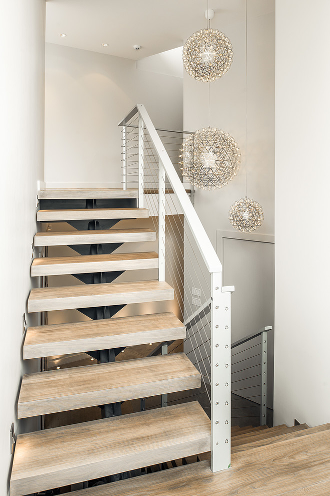 This is an example of a large contemporary wood floating staircase in Vancouver with open risers.