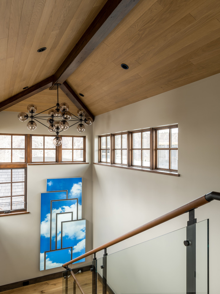 Ejemplo de escalera en U contemporánea extra grande con escalones de madera, contrahuellas de madera y barandilla de vidrio