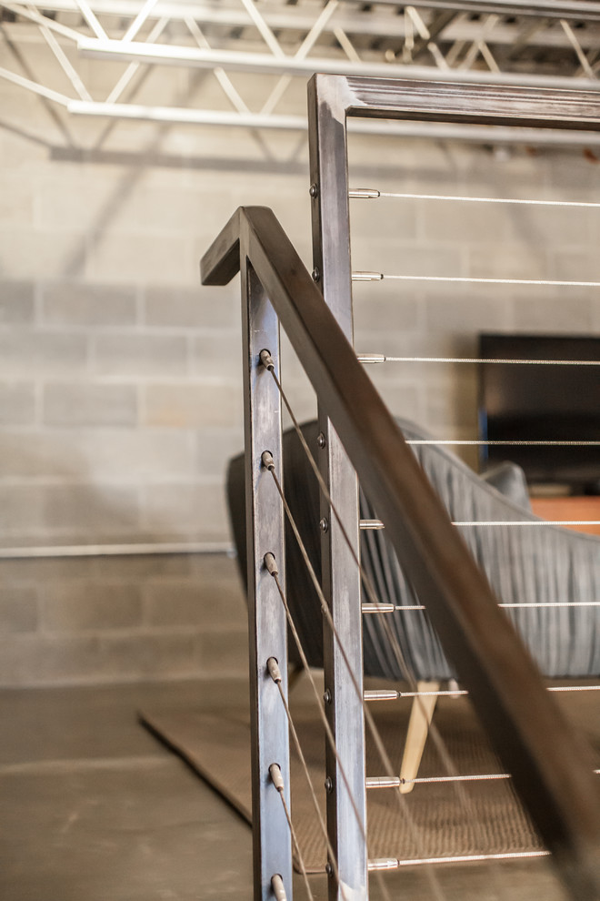 Diseño de escalera industrial con escalones de metal, contrahuellas de metal y barandilla de cable