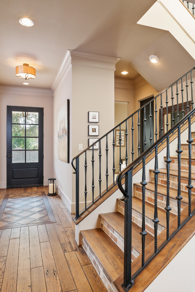 Design ideas for a wood u-shaped metal railing staircase in Houston with feature lighting.