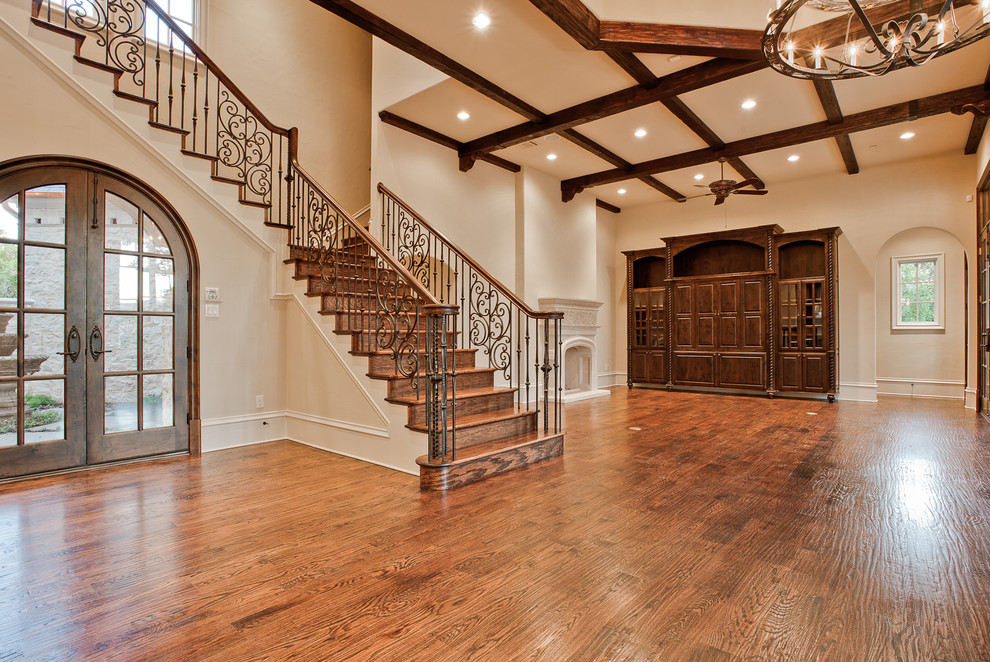 Inspiration for a large mediterranean wood curved metal railing staircase in Dallas with wood risers.