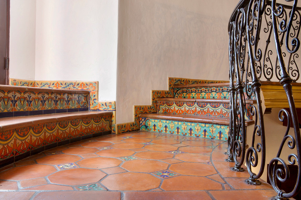 Imagen de escalera curva clásica grande con escalones con baldosas y contrahuellas con baldosas y/o azulejos