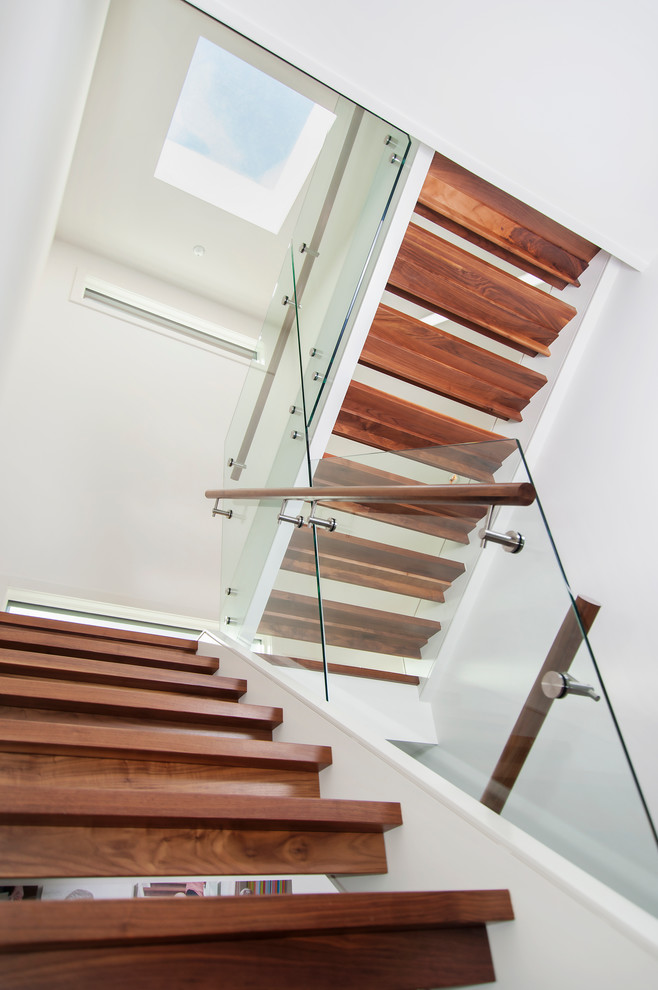 Medium sized midcentury wood u-shaped staircase in Calgary with open risers.