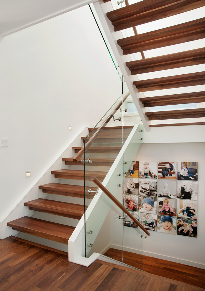 This is an example of a medium sized contemporary wood u-shaped staircase in Calgary with open risers.
