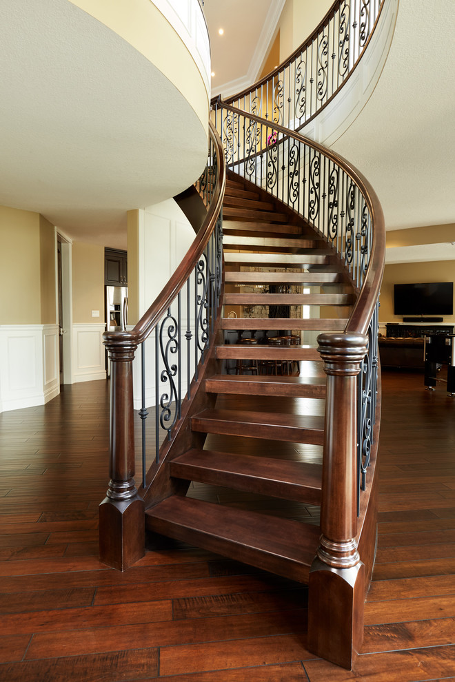 Источник вдохновения для домашнего уюта: изогнутая лестница в классическом стиле с деревянными ступенями и деревянными перилами без подступенок