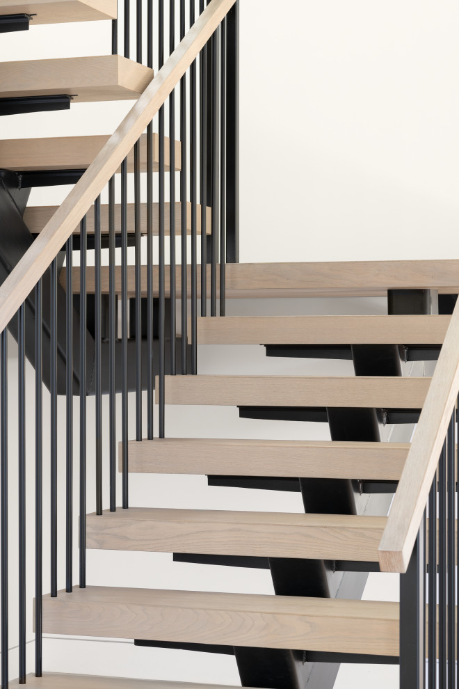 Diseño de escalera moderna sin contrahuella con escalones de madera y barandilla de metal
