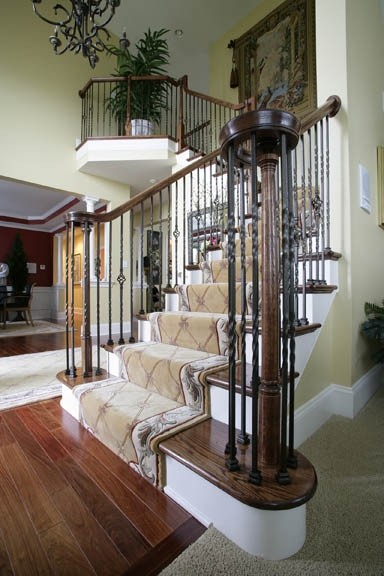 Diseño de escalera en L tradicional de tamaño medio con escalones de madera, contrahuellas de madera pintada y barandilla de metal