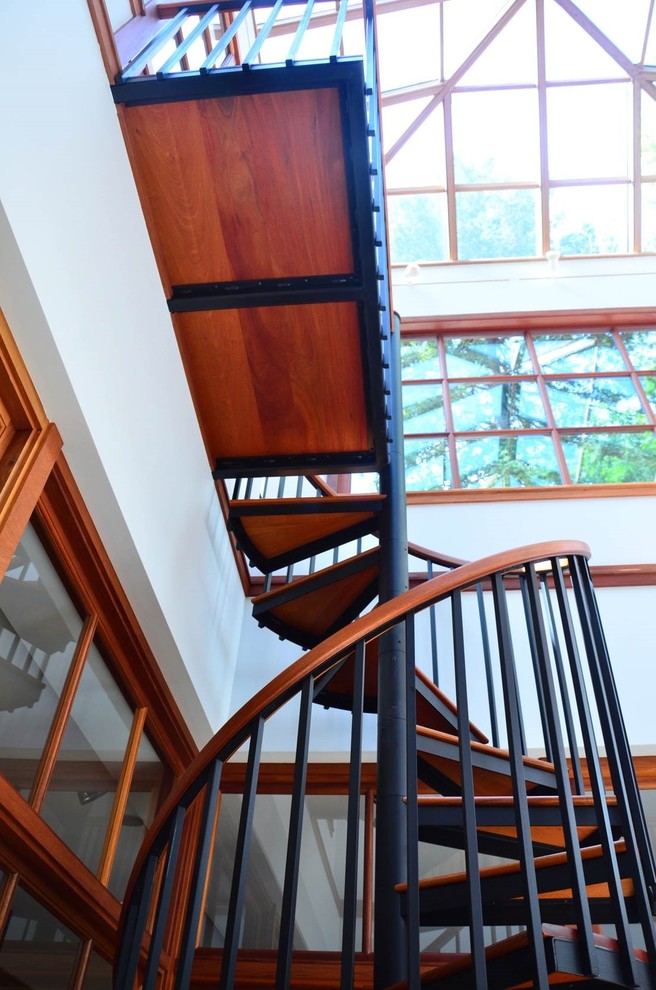 Inspiration pour un escalier sans contremarche hélicoïdal traditionnel de taille moyenne avec des marches en bois et un garde-corps en bois.