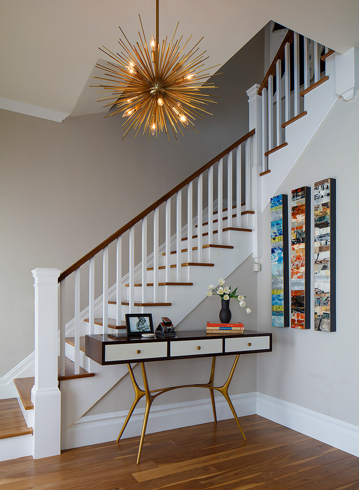 Стильный дизайн: угловая лестница в стиле неоклассика (современная классика) с деревянными ступенями и крашенными деревянными подступенками - последний тренд