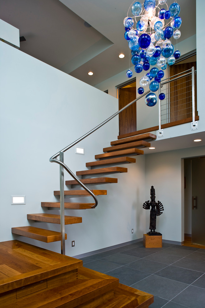 Стильный дизайн: большая лестница на больцах в стиле модернизм с деревянными ступенями без подступенок - последний тренд