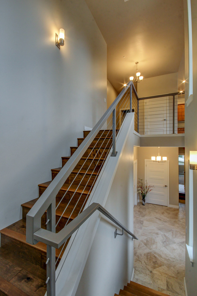 This is an example of a medium sized contemporary wood u-shaped wire cable railing staircase in Other with wood risers.