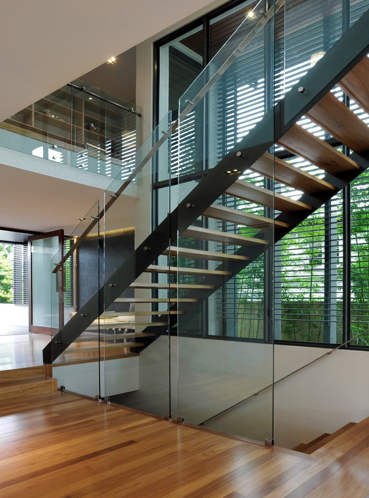 This is an example of a large contemporary wood straight mixed railing staircase with open risers.