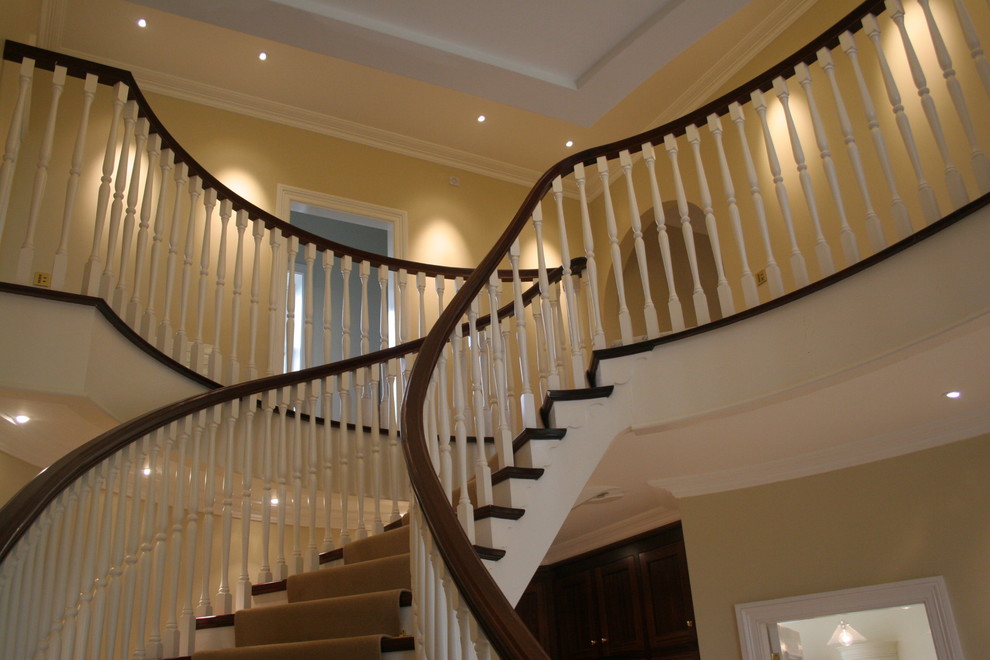 Photo of a large traditional wood spiral staircase in Other with wood risers.