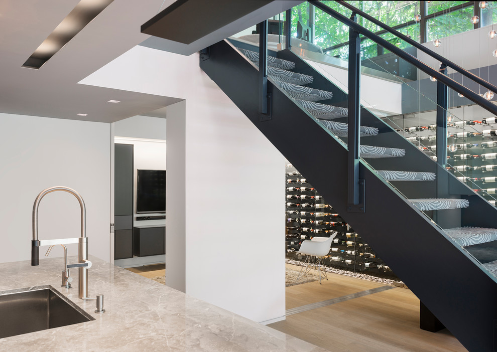Пример оригинального дизайна: лестница среднего размера, на больцах в современном стиле с ступенями с ковровым покрытием и стеклянными перилами без подступенок