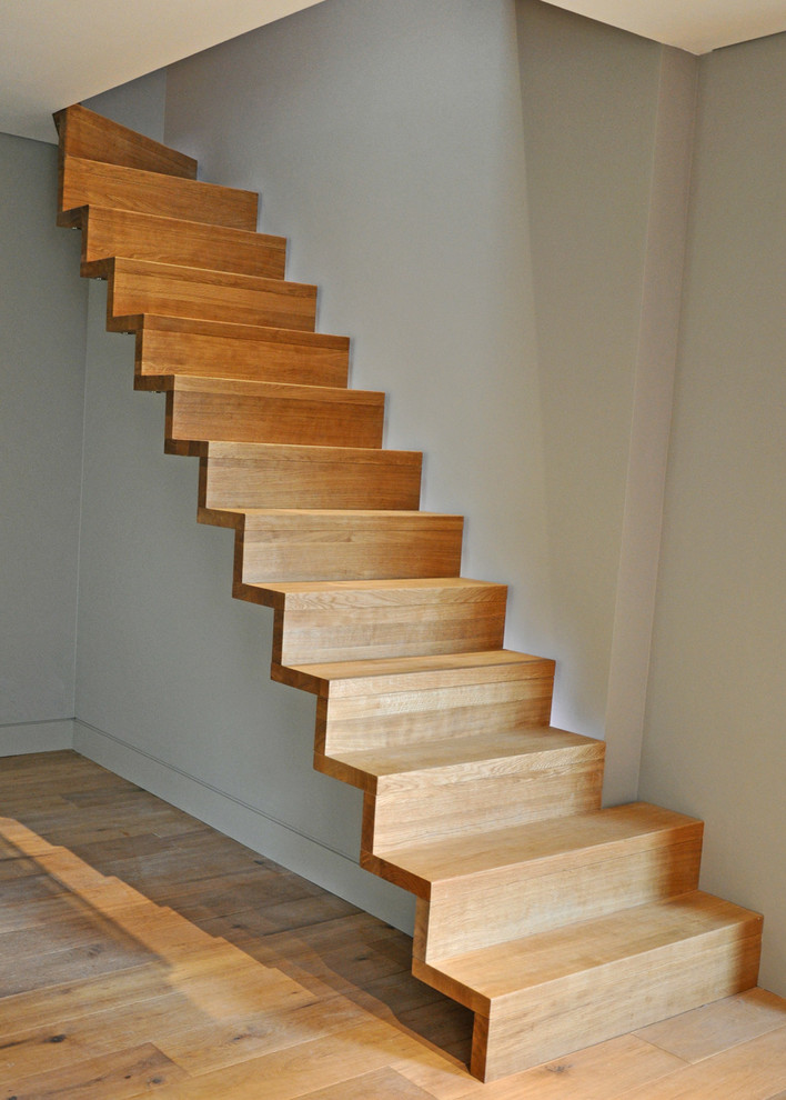 Design ideas for a small contemporary wood straight glass railing staircase in Buckinghamshire with wood risers.