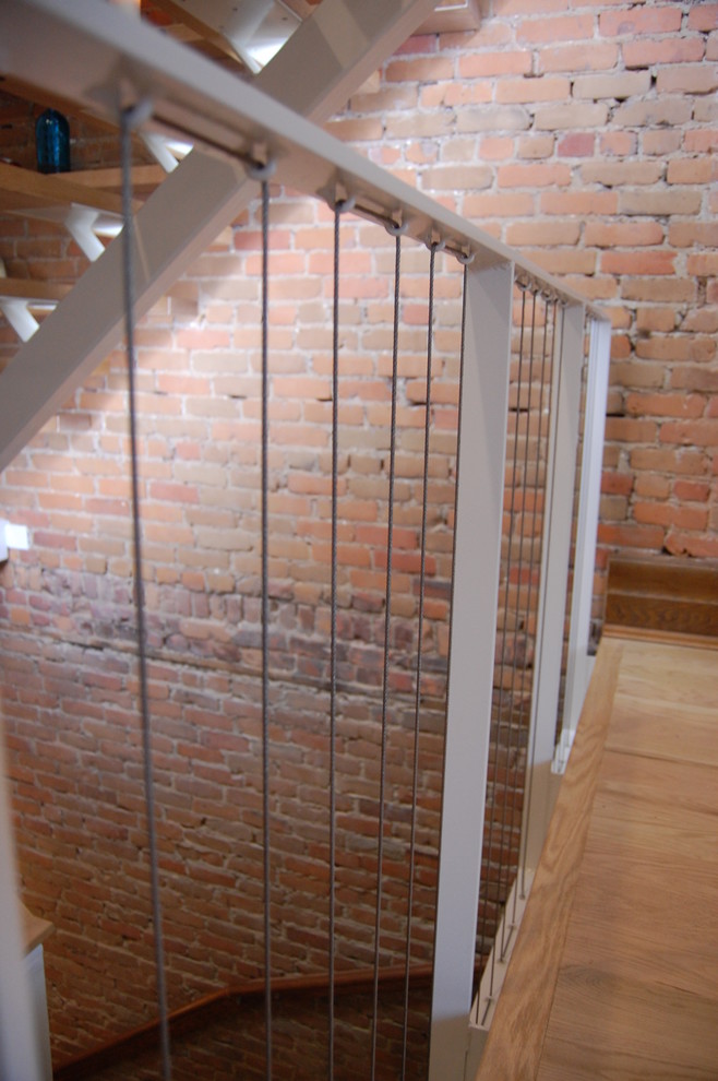 Idées déco pour un escalier sans contremarche éclectique en L avec des marches en bois et un garde-corps en métal.