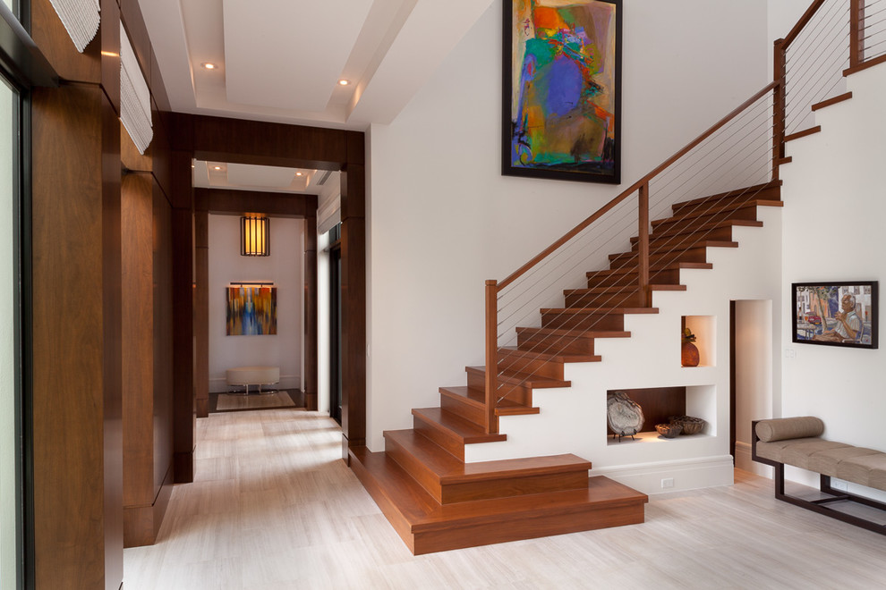 Foto de escalera en L contemporánea de tamaño medio con escalones de madera, contrahuellas de madera y barandilla de cable