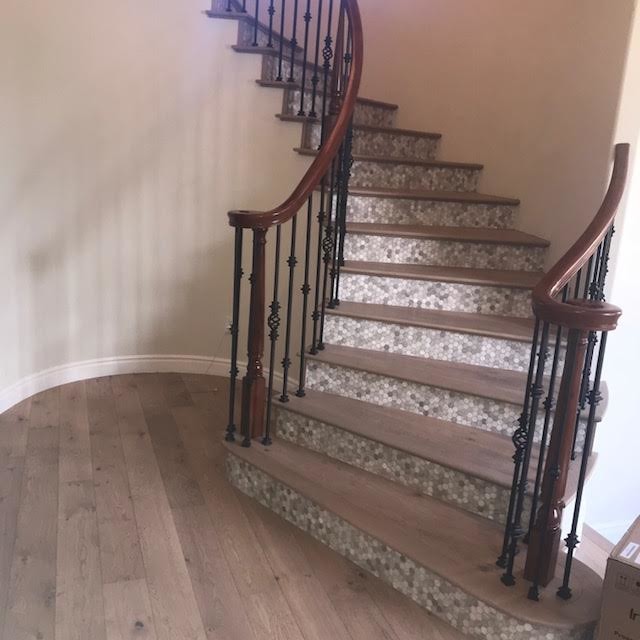 Foto de escalera curva actual grande con escalones de madera, contrahuellas con baldosas y/o azulejos y barandilla de varios materiales
